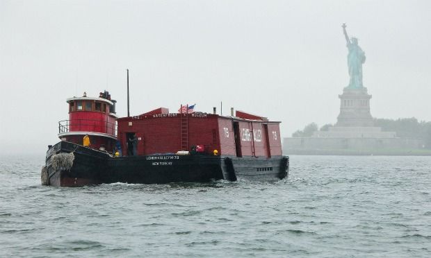 The tugboat Pegasus and the Lehigh Barge no. 79 passing the Statue of Liberty in the rain.